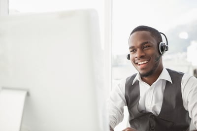 Smiling businessman with headset interacting in his office-1